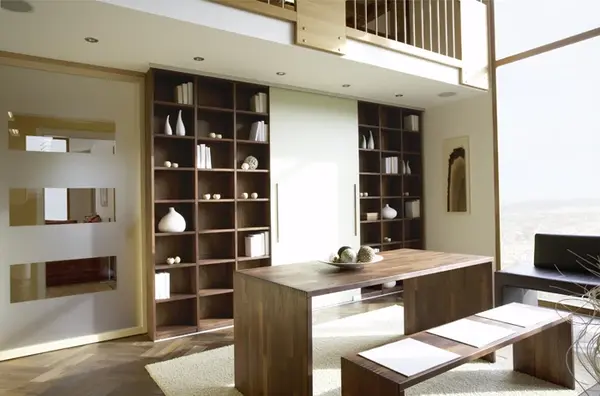 Modernes Esszimmer mit Holztisch, Bank, Bücherregal und großen Fenstern mit Tageslicht.