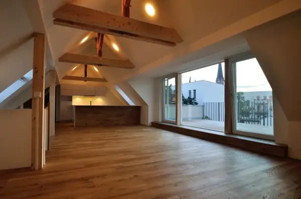 Helles, modernes Loft mit sichtbaren Holzbalken, Parkettboden und großer Terrasse.